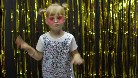 Stylish-child-dancing,-make-faces,-waving-hand-in-silly-dance.-Little-blonde-kid-girl-4-5-years-old