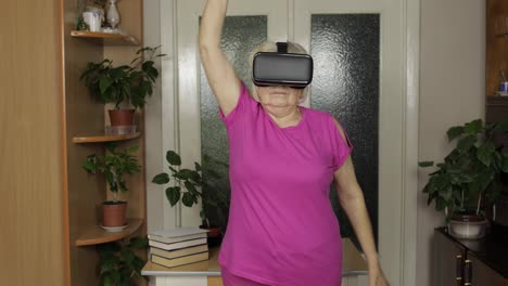 Großmutter-Mit-Virtueller-Headset-Brille-Schaut-Sich-Videos-Im-VR-Helm-An-Und-Trainiert-Zu-Hause