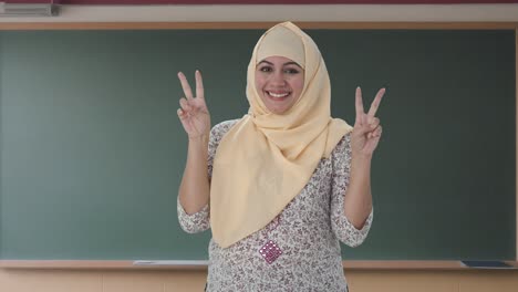 Glücklicher-Muslimischer-Lehrer,-Der-Siegeszeichen-Zeigt