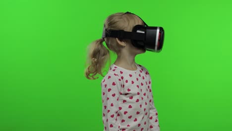 Child-girl-using-VR-headset-helmet-to-play-game.-Watching-virtual-reality-3d-360-video.-Chroma-key