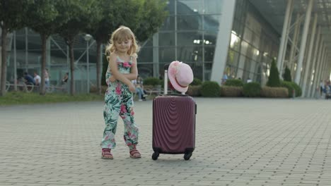 Kind-Mädchen-Tourist-Mit-Koffer-Gepäcktasche-In-Der-Nähe-Des-Flughafens.-Kind-Tanzt,-Freut-Sich,-Feiert