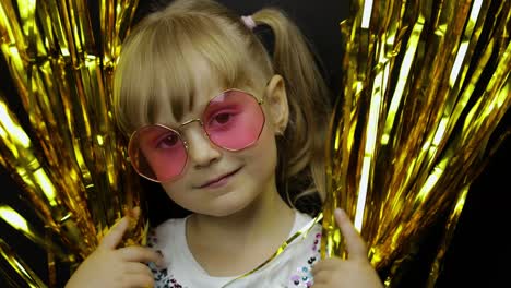 Portrait-of-happy-child-playing,-fooling-around-in-foil-fringe-golden-curtain.-Little-blonde-kid