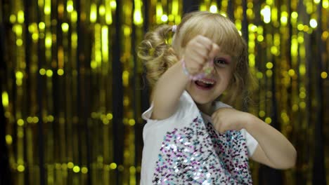 Child-kid-dancing,-celebrating-victory,-fooling-around.-Girl-posing-on-background-with-foil-curtain