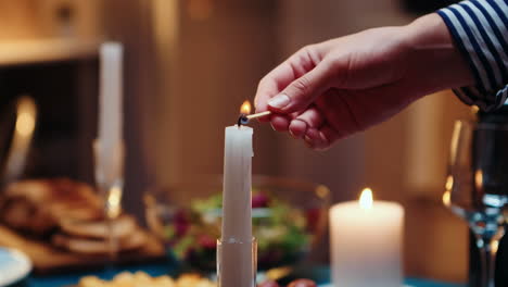 Close-up-of-woman-lighting-the-candle