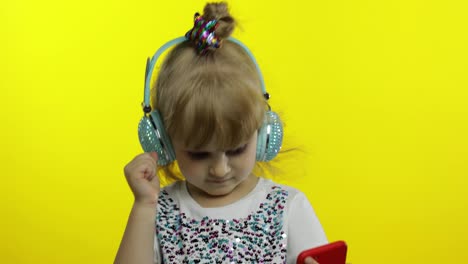 Kind-Tanzt-Mit-Smartphone-Und-Hört-Musik-über-Kopfhörer.-Kleines-Mädchen-Tanzt,-Hat-Spaß