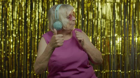 Senior-old-woman-dances,-listens-music-on-headphones.-Relaxing,-enjoying,-having-fun,-smiling