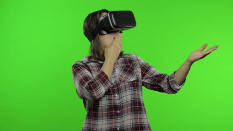 Young-woman-using-VR-headset-helmet-to-play-game,-showing-side-advertising-area.-Chroma-key