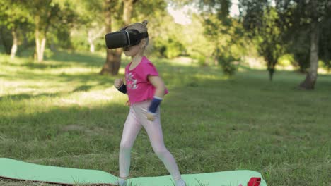 Athletic-child-girl-in-VR-headset-helmet-making-fitness-workout-exercises-in-park.-Virtual-reality