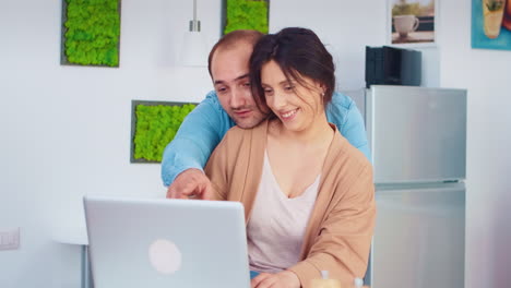 Cheerful-couple-using-laptop