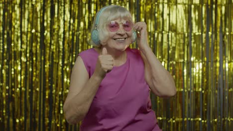 Senior-old-woman-dances,-listens-music-on-headphones.-Relaxing,-enjoying,-having-fun,-smiling