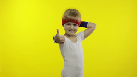 Happy-cute-girl-in-white-sportswear-showing-thumb-up-gesture-isolated-on-yellow-background.-Fitness