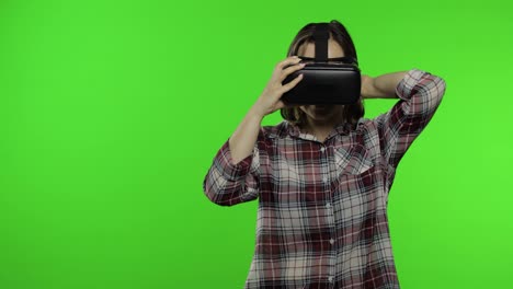 Junge-Frau-Benutzt-VR-Headset-Helm,-Um-Ein-Spiel-Zu-Spielen,-Und-Zeigt-Seitlichen-Werbebereich.-Chroma-Key