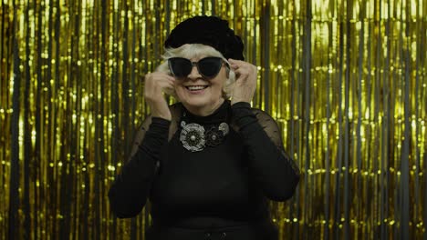 Elderly-stylish-grandmother.-Caucasian-woman-posing-on-golden-background