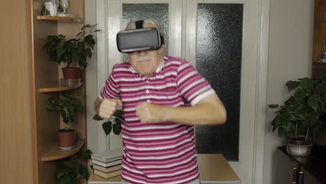 Älterer-Großvater-Mit-Virtueller-Headset-Brille,-Der-Sich-Videos-Im-3D-VR-Helm-Ansieht-Und-Tanzt-Und-Spaß-Hat