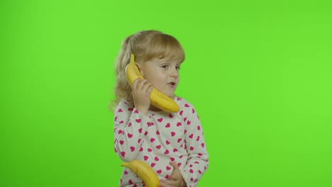 Niña-Feliz-Imitando-Una-Conversación-Telefónica-Con-Plátano-Aislado-En-El-Fondo-De-La-Clave-Croma