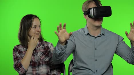 Man-and-woman-using-VR-headset-helmet-to-play-game.-Watching-virtual-reality-3D-video.-Chroma-key