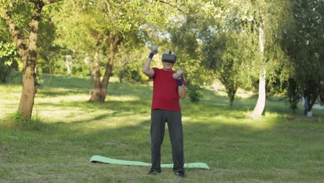 Älterer-Alter-Großvater-Mit-VR-Headset-Helm-Macht-Fitnessübungen-Mit-Hanteln-Im-Park