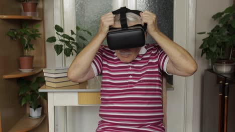 Der-ältere-Großvater-Setzt-Eine-Virtuelle-Headset-Brille-Auf-Und-Schaut-Sich-Zu-Hause-3D-Videos-Im-360-VR-Helm-An