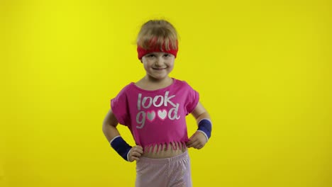 Ein-Sportliches-Mädchen-In-Rosa-Sportkleidung-Winkt-Mit-Der-Hand-Und-Macht-Eine-Hallo-Geste-Auf-Gelbem-Hintergrund
