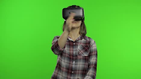 Girl-using-VR-app-helmet-to-play-simulation-game.-Slide-gestures.-Watching-virtual-reality-3d-video