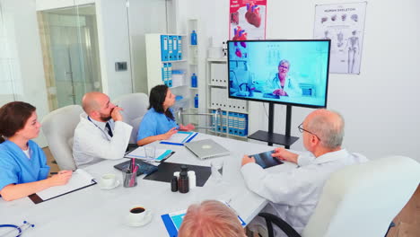 Team-of-medical-staff-during-video-conference-with-doctor-in-hospital