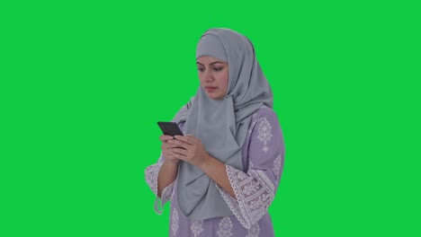 Muslim-woman-typing-on-phone-Green-screen