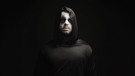 Young-man-with-scary-make-up-dressed-up-like-grim-reaper