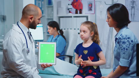 Doctor-and-patients-looking-at-green-screen-tablet