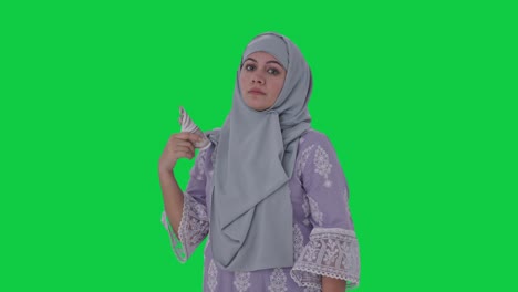 Serious-Muslim-woman-money-as-fan-Green-screen