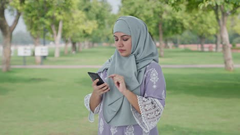 Mujer-Musulmana-Seria-Usando-El-Teléfono-En-El-Parque