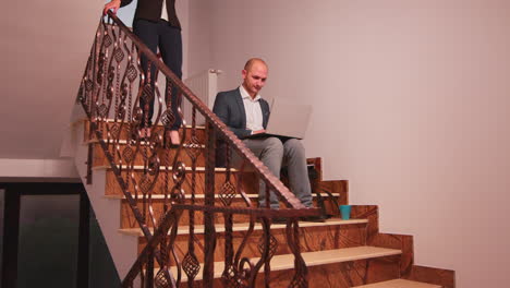 Company-manager-using-laptop-overworking-on-stairs