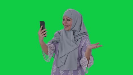 Glückliche-Muslimische-Frau,-Die-über-Einen-Videoanruf-Auf-Grünem-Bildschirm-Spricht