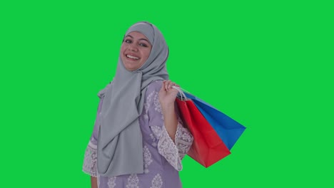 Glückliche-Muslimische-Frau-Posiert-Mit-Einkaufstüten-Auf-Grünem-Bildschirm