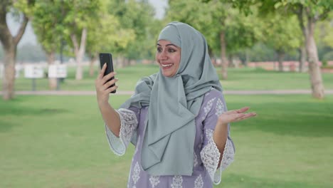 Happy-Muslim-woman-talking-on-video-call-in-park