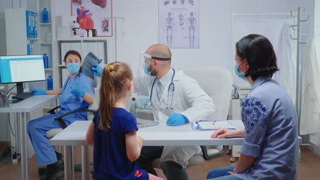 Radiologe-Mit-Schutzmaske-Bittet-Um-Röntgenaufnahme-Eines-Kindes
