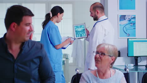 Arzt-überprüft-Röntgenbild-Auf-Krankenschwester-Digital-Tablette