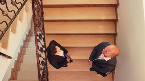 Top-view-of-partners-meeting-on-stairs-shaking-hands