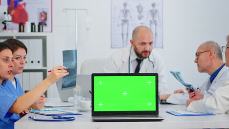 Team-of-physicians-using-laptop-with-green-screen-in-front-of-camera