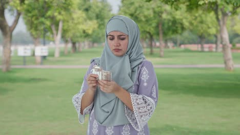Triste-Mujer-Musulmana-Contando-Dinero-En-El-Parque