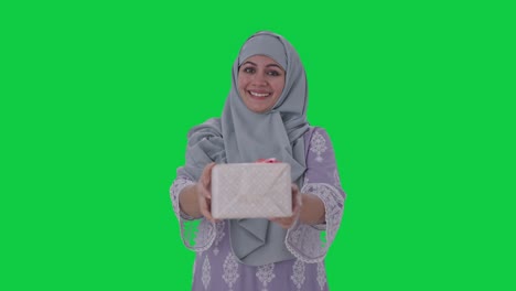 Glückliche-Muslimische-Frau,-Die-Ein-Geschenk-Auf-Grünem-Bildschirm-Macht
