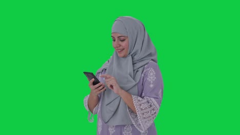 Glückliche-Muslimische-Frau,-Die-Den-Grünen-Bildschirm-Des-Telefons-Benutzt