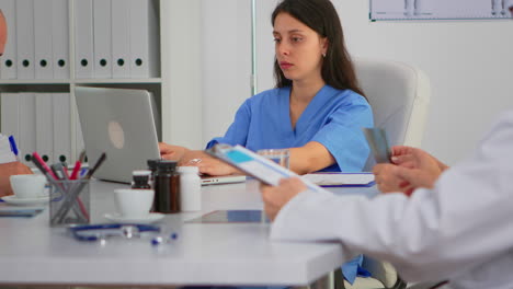 Portrait-of-nurse-typing-on-laptop-looking-at-camera