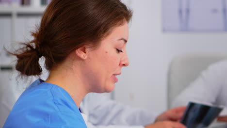 Close-up-of-young-woman-nurse-discussing-with-colleague