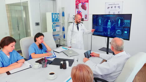 Medical-expert-talking-about-healthcare-pointing-at-digital-monitor