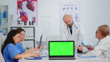 Medizinische-Kollegen,-Die-Im-Krankenhausbüro-Arbeiten-Und-Einen-Laptop-Mit-Modelldisplay-Verwenden