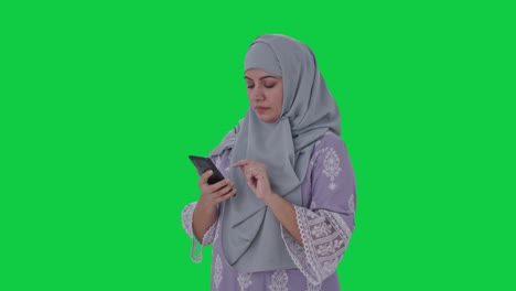 Ernsthafte-Muslimische-Frau,-Die-Den-Grünen-Bildschirm-Des-Telefons-Benutzt
