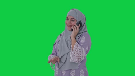 Serious-Muslim-woman-talking-on-phone-Green-screen