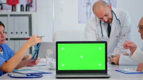 Ärzteteam-Platziert-Laptop-Mit-Grünem-Bildschirm-Vor-Der-Kamera