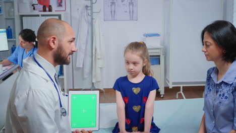 Doctor-talking-and-holding-a-green-screen-tablet