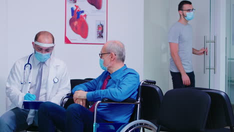 Arzt-Berät-Behinderten-älteren-Mann-Im-Wartebereich-Des-Krankenhauses